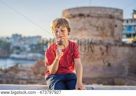 Boy Tourist Eating Turkish Ice Cream On Background Of Hidirlik Tower In Antalya Against The Backdrop