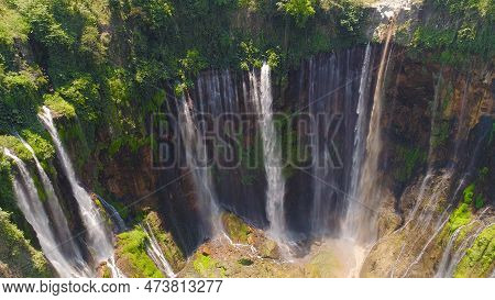 Aerial View Waterfall Coban Sewu In Java, Indonesia. Waterfall In Tropical Forest By Drone Tumpak Se