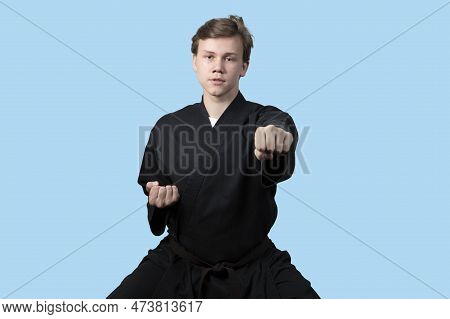 Taekwando.a Teenager In A Black Kimano Who Is Engaged In Taekwando.