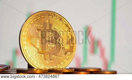 Bitcoin Crypto On The Background Of Blurry Price Graphic. High Quality Photo