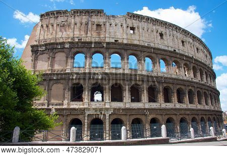 The Photo Shows The Colosseum, An Iconic Landmark Of Ancient Rome, In The Afternoon. The Sun Casts A