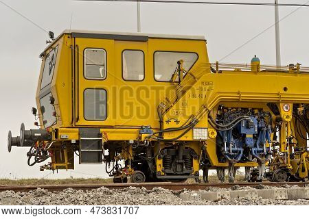 Construction Of Railway Tracks. Laying Rails And Compacting Gravel On Which Railway Sleepers Are Pla