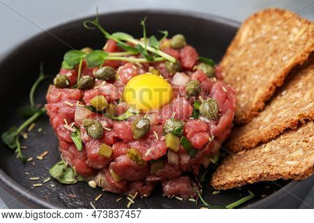 Tasty Beef Steak Tartare Served With Yolk, Capers And Bread In Serving Pan, Closeup