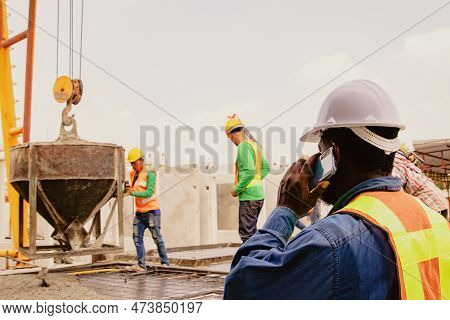 African American Foreman Discusses Taking Over The Work Pouring Concrete Into Square Block Molds Bei