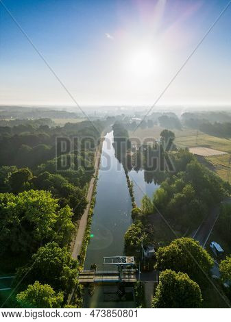 Aerial View Of A Colorful Dramatic Sunrise Sky Over A Canal With A Draw Bridge In Belgium. Canals Wi