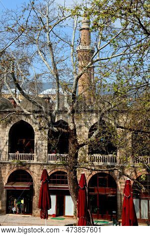 Courtyard View Of The Two-story Koza Han Market With Shops Inside With A Minaret In The Background A