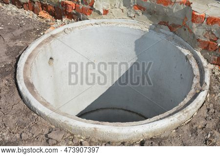 Concrete Septic Tank Riser Installation Outdoors. Close Up On Septic Tank Riser In The Ground Hole.