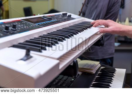 A Pianist Or Keyboardist Plays A Synthesizer