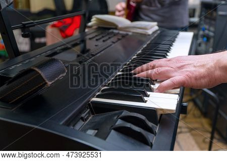 A Pianist Or Keyboardist Plays A Synthesizer