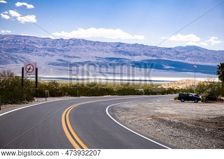 Empty Road In Death Valley, California. Paramint Springs Resort In Background. Usa