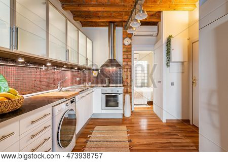 Stylish Cozy Kitchen With Modern Appliances And Wooden Loft Ceiling Overlooking The Open Bedroom Wit