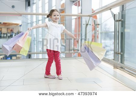 Jovem carregada de sacolas de papel