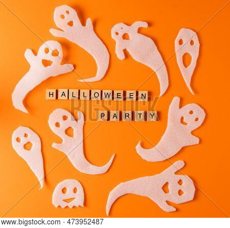 White Ghosts Craft For Halloween Party. Paper Ghost On Orange Background. Cartoon Creepy Whisper. Di