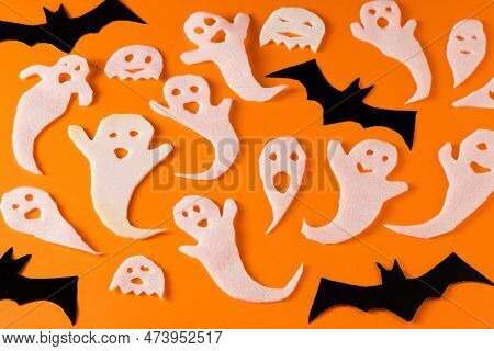 White Ghosts And Bat Craft For Halloween Party. Wrapping Paper Ghost On Orange Background Top View. 