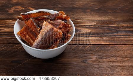 Pieces Of Cleaned Dried Fish Isolated On Wooden Background. Dry Peppered Pollack. Amber With Pepper.