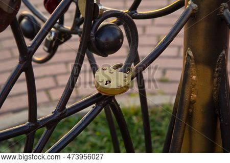 Several Locks Of Different Colors Hang On The Iron Structure