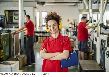 A Proud Printing Shop Manager With Antiphons Smiling At The Camera.