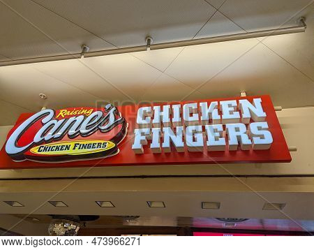 Honolulu - February 21, 2022:   Raising Cane's Chicken Fingers Sign Above Restruant Inside Mall.