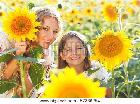 Happy Mother And Her Little Daughter In The Sunflower Field