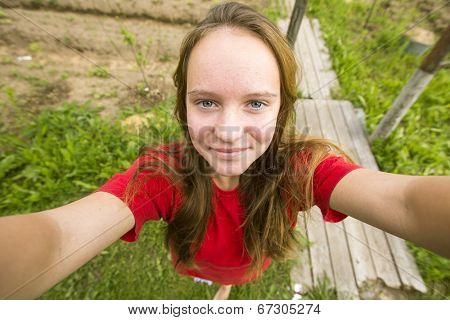 Teengirl taking a selfie (self-portrait) out in the country house.