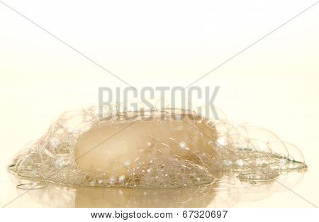 Piece of toilet soap and soapsuds with air bubbles