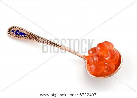 Caviar de salmão em uma colher de prata dourada, isolado