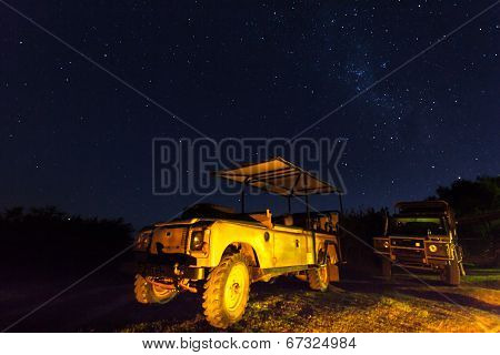 Landrovers with golden reflection under the stars