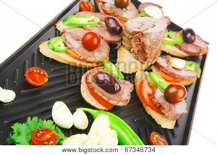 snakes on black teflon grill plate : meaty tartlets with supplements isolated over white background