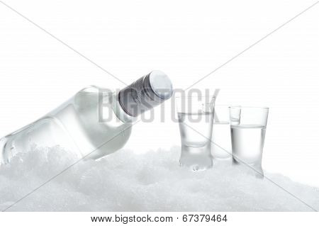 Bottle And Glasses Of Vodka Lying On Ice On White