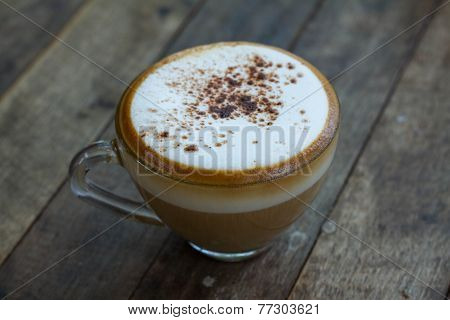 A cup of coffee in a white cup on wooden