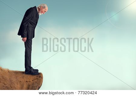 Senior Man Looking Down From A Cliff