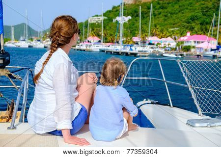 Back view of mother and daughter family sailing on a luxury yacht or catamaran boat