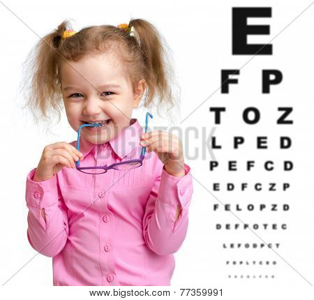 Smiling girl took off glasses with blurry eye chart behind her