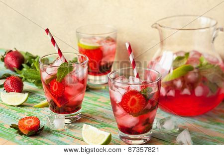 Refreshing summer drink with Strawberry in jug and glasses on the vintage wooden table