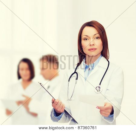 healthcare and medicine concept - calm female doctor with clipboard and stethoscope