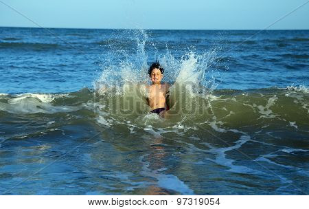 Brave Child Plunges Over The Waves Of The Choppy Sea