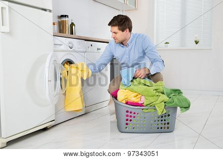 Man Loading Clothes Into Washing Machine