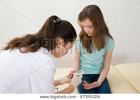 Doctor Measuring Blood Sugar Level Of Girl