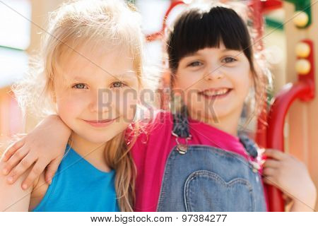 summer, childhood, leisure, friendship and people concept - group of happy little girls on children playground climbing frame