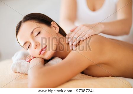 beauty, spa, resort and relaxation concept - beautiful woman in spa salon getting massage