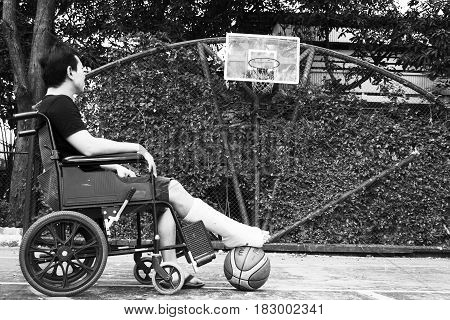 Man Standing With Broken Leg In Plaster Cast Using Crutches At Basketball Court