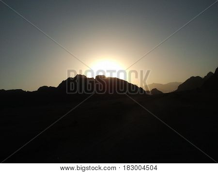 Stunning sunset behind the beautiful mountains on hot sunny day
