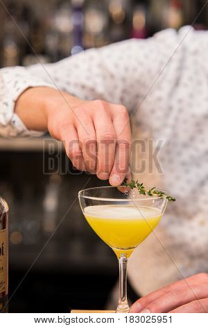 Closeup of barman hand putting on a glass to prepare cocktail.
