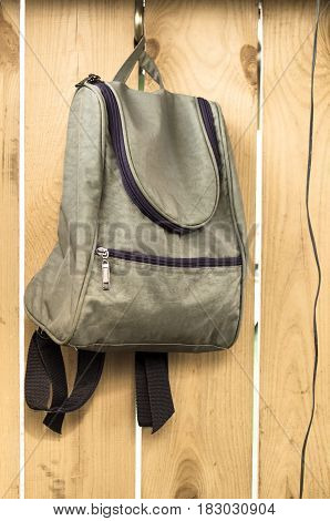 Bag (backpack) on wooden wall background. Education concept.