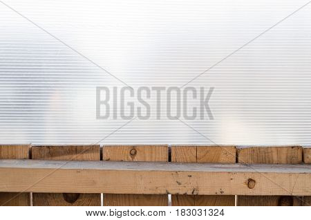 Polycarbonate surface and wooden planks wall background.