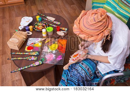 Woman, Folk Craftsman, Is Engaged In Painting On Wood