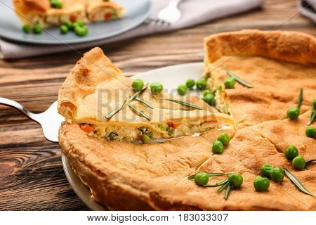 Tasty chicken pot pie with green peas on plate, closeup