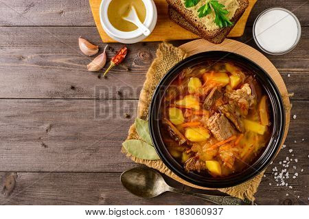 Shchi - traditional russian cabbage soup on wooden table. Rustic style. Top view.