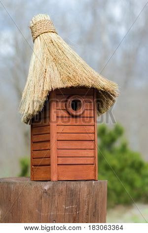 Nesting box. Wooden nest box handmade with thatched roof. Wooden house for birds