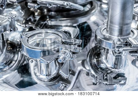 Pharmaceutical equipment, a lot of metal nipples and flanges. Abstract industrial background.